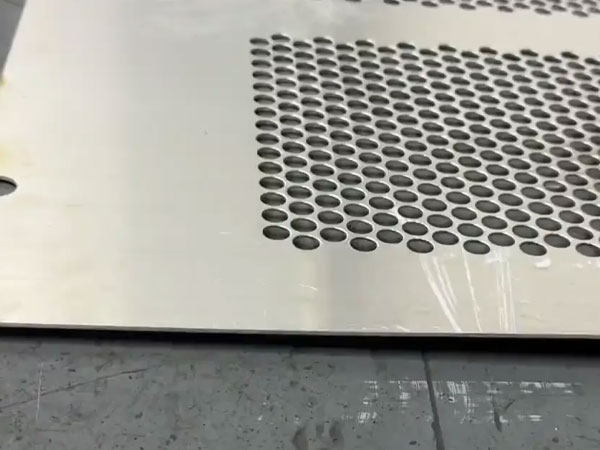 Why do perforated metal sheets bend and deform after manufacturing?